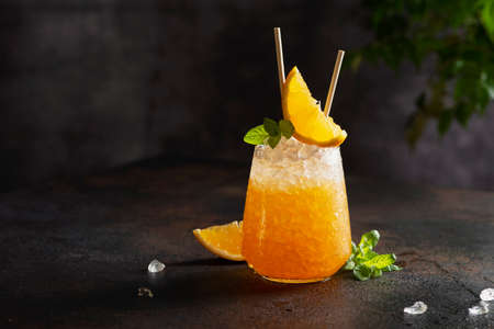 Fresh cold cocktial with orange, crushed ice and mint, selective focus image and bar conceptの写真素材