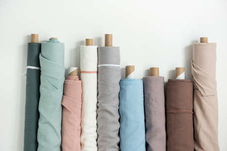 Different colors fabric linen rolls on the white walls, selective focus imageの写真素材