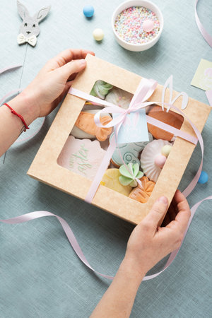 Mix of Easter cookies in the paper box on the light bluetable, selective focus image