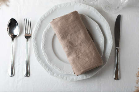 Table decor concept, linen white tablecloth and beige napkin, selective focus image