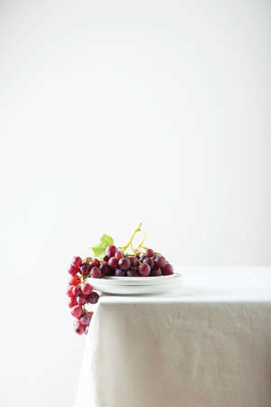 Red grape on the white linen tablecloth, selective focus imageの写真素材