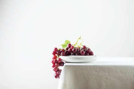 Red grape on the white linen tablecloth, selective focus imageの写真素材
