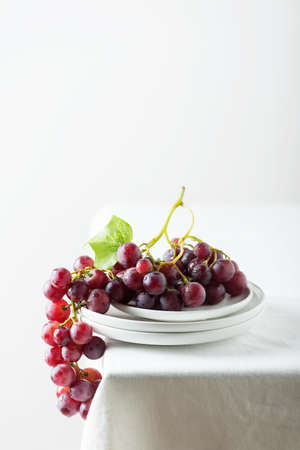 Red grape on the white linen tablecloth, selective focus imageの写真素材