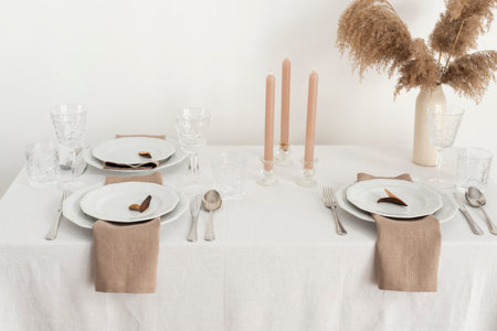 Concept of table decoration with linen white tablecloth and beige napkins, selective focus imageの写真素材