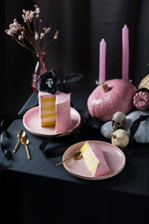 Halloween party table decoration with pink cake and black tablecloth, selective focus imageの写真素材