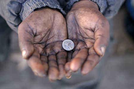 A Gipsy's hands holding a silver coinの写真素材