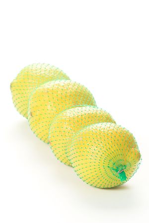 Four lemons in a green net bagの写真素材
