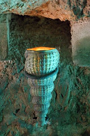 Shell shaped torch attached to a rustic wallの写真素材
