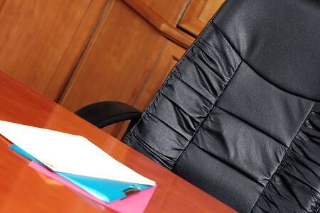 Black leather chair in a boardroom with files on the tableの写真素材