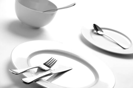 Dinner table setting of empty plates over whiteの写真素材