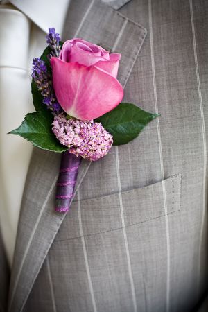 Pink rose boutonniere pinned to a grooms jacket.の写真素材