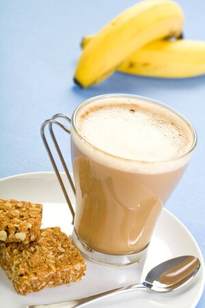 Nice hot cup of coffee in a see through cup with some healthy biscuits.の写真素材