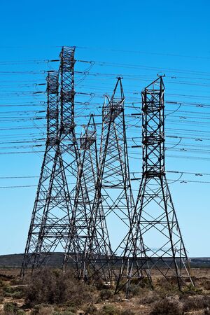 Electrical towers with a blue sky in the background.の写真素材