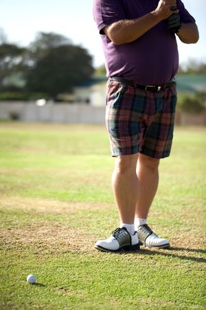 Golfers legs on his follow through.