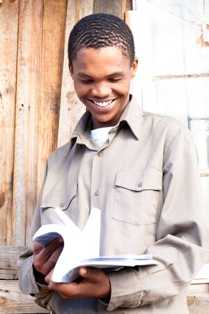 Friendly black student paging through his book.の写真素材