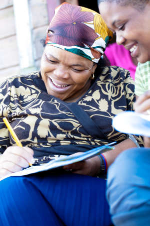 A lady sign a paper while the other one watchの写真素材