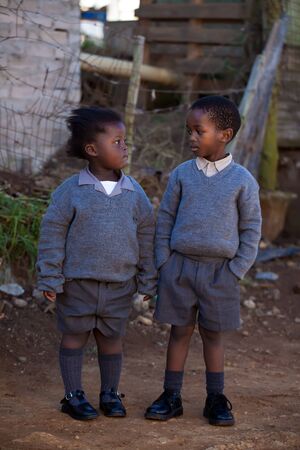 Boy with an attitude looking at his fragile little sisterの写真素材