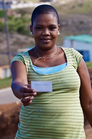 A woman showing the  card of the person.の写真素材