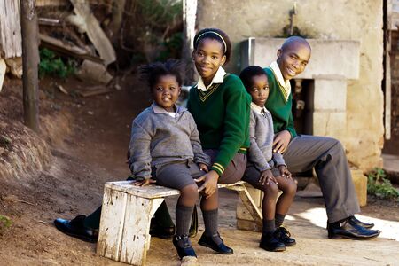 This family of school kids waiting for the bus to their way to school.の写真素材