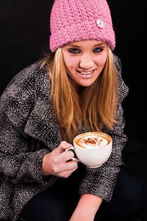 A young lady with a good cup of cuppuccino.の写真素材