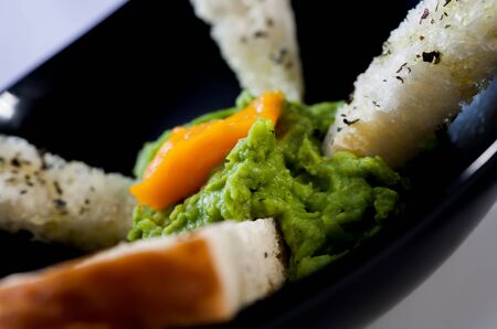 Baked bread with avocado patry and peahes on top.の写真素材