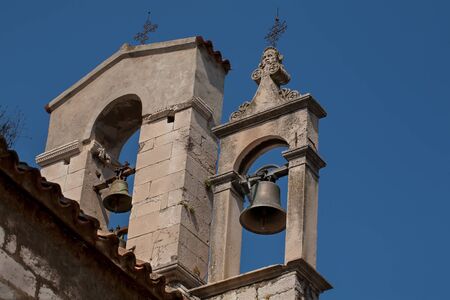 Two bell towers in Croatia with crosses on top.の写真素材