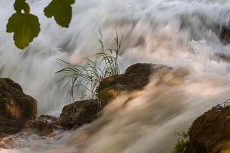 The river is flowing on high speeds over the rocks.の写真素材