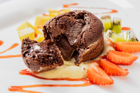 Chocolate souffle with running choclate is served with fresh strawberries の写真素材