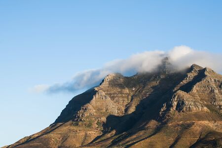 A huge cloud is laying over the mountains of Cape Town.の写真素材