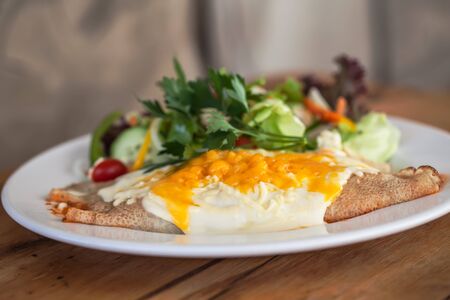 Pancakes is serve with eggs and salad.の写真素材