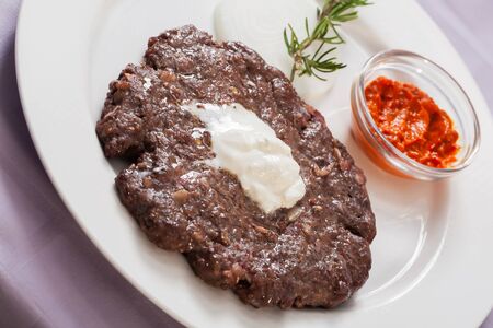 Piece of beef is served on a platewith chilli sauce.の写真素材