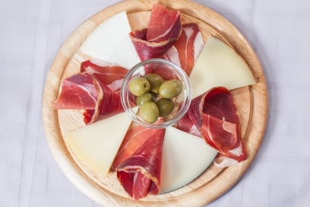 Cheese and bacon platter served with some olives.の写真素材