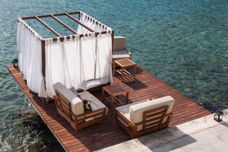 Bead and lounge situated on a deck on the beach.の写真素材