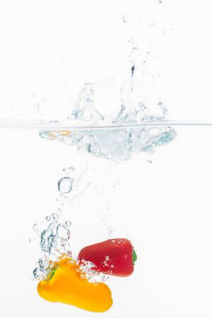 Red and yellow spices thrown into a bowl of water.の写真素材