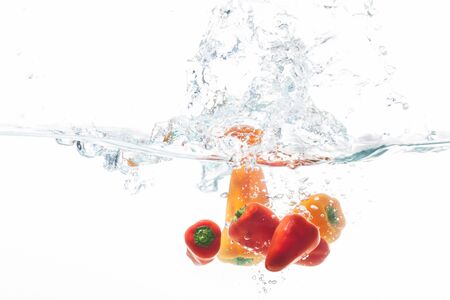 The orange and red spices are being cleaned in water.の写真素材