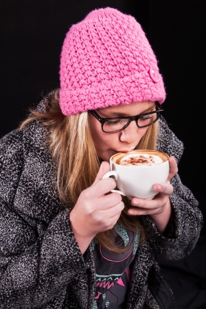 The girl is drinking a nice cup of coffee for that extra warmthの写真素材