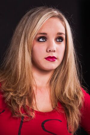 A young girl with beautiful green eyes, dressed in red.の写真素材