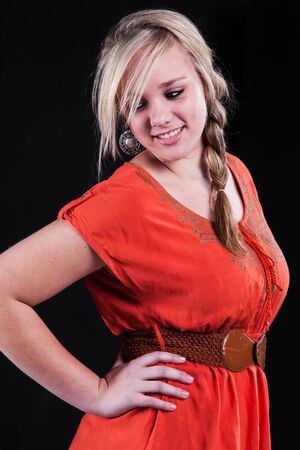 Dressed in a shocking orange dress and brown belt, the girl is showing the country style.の写真素材