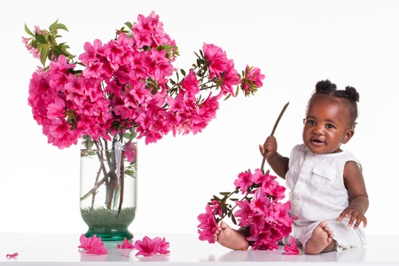 Little girl on the table bunch of pink flowers in the hand.の写真素材