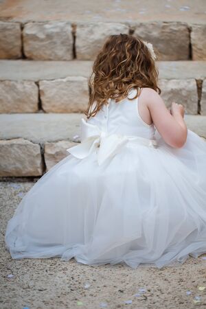 The little girl are picking up the confetti from the ground.の写真素材