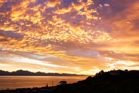 Golden, yellow skies are lighting up the ocean.の写真素材