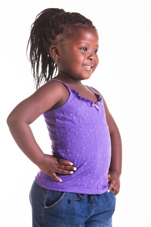 A little African girl dressed in purple blouse, blue jeans and black heels.の写真素材