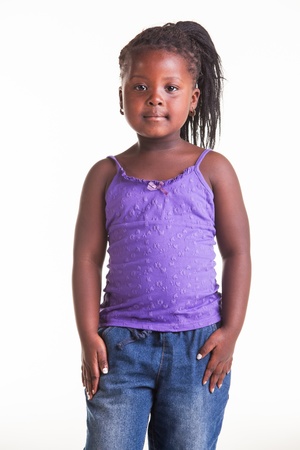 A little African girl dressed in purple blouse, blue jeans and black heels.の写真素材