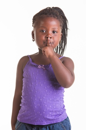 A little African girl dressed in purple blouse, blue jeans and black heels.の写真素材