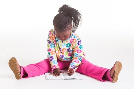 A young African girl being photographed in flowers sweater and pink jeans.の写真素材