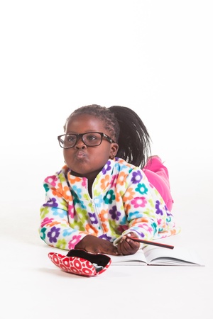 A young African girl being photographed in flowers sweater and pink jeans.の写真素材