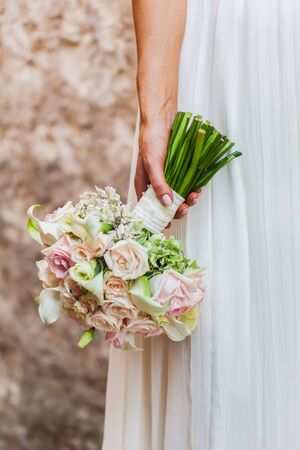 The bride with her beautiful bouquet filled with pink roses and other.の写真素材
