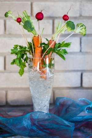 Carrot and berries ikebana decorations in a glass vase の写真素材