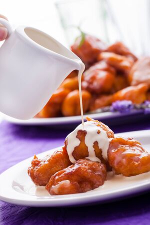 A big plate of freshly made saucy and golden pumpkin fritters.の写真素材