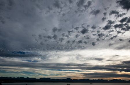 Dark grey sky with darker spots in the light の写真素材